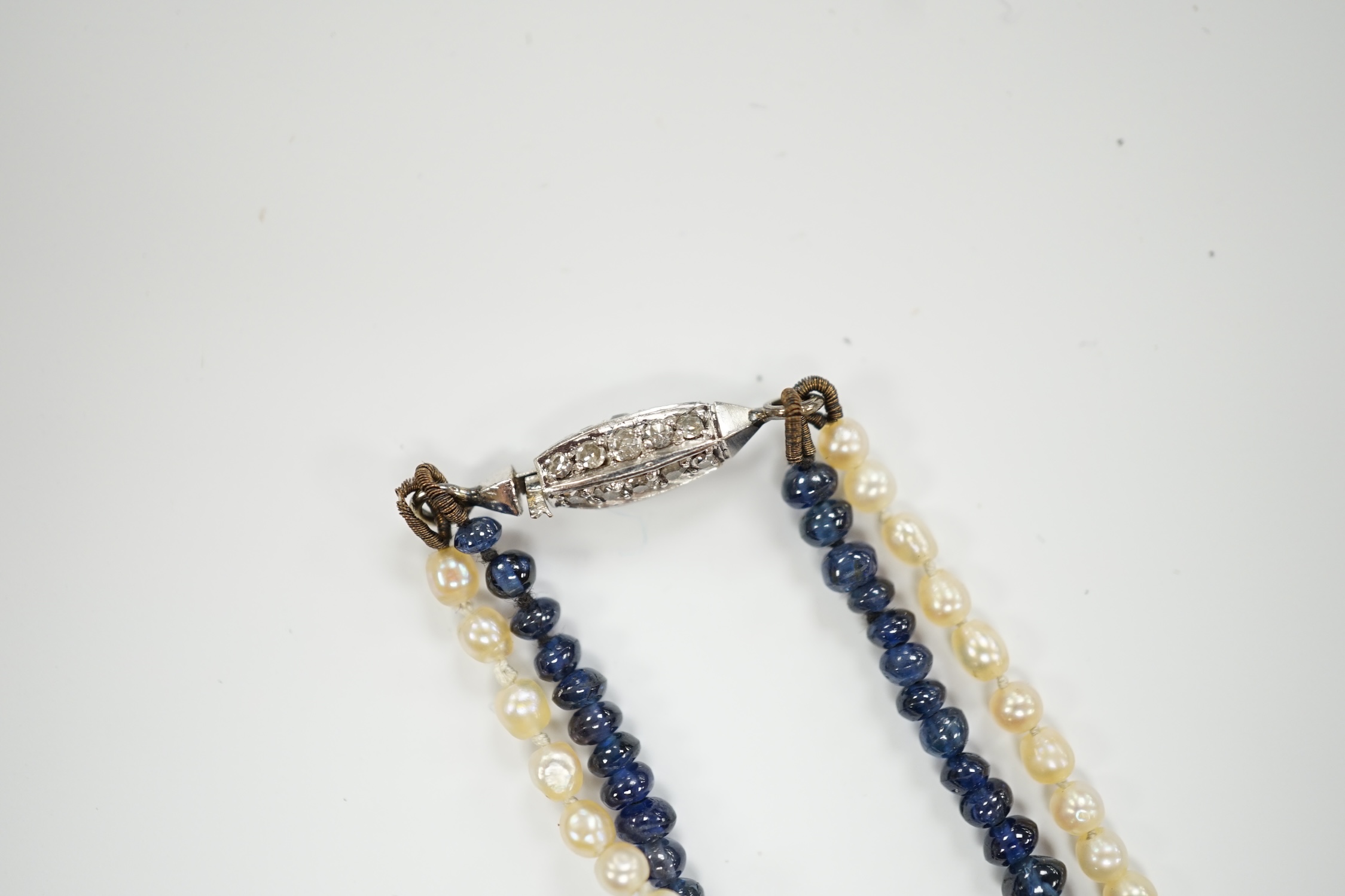 A twin strand gradated seed pearl and graduated sapphire bead necklace, with diamond chip set white metal clasp, 36cm, in original F. Chiappe, Gioielliere, Genova box.
